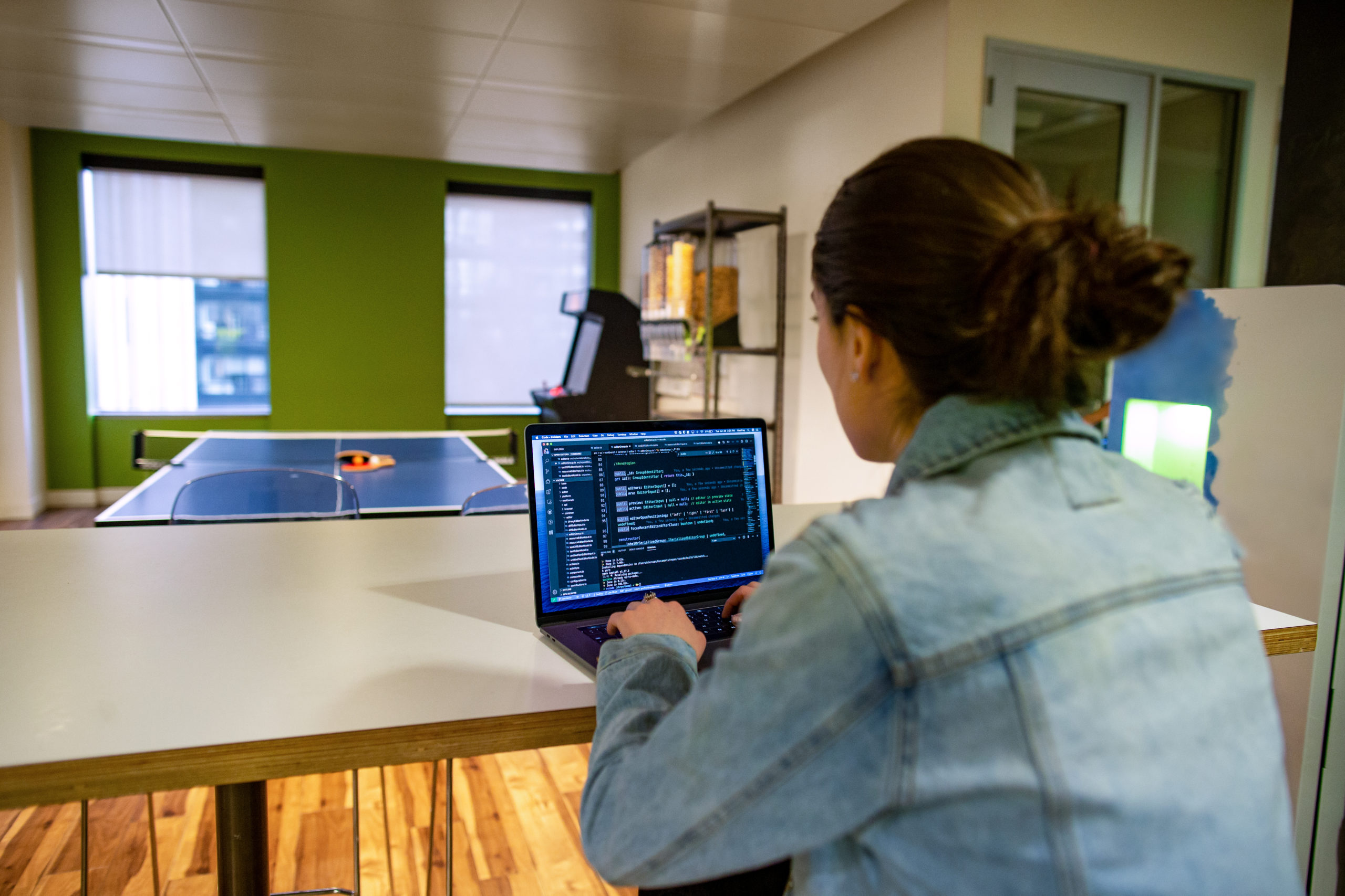 Female developer working on the go from the office breakroom or kitchen.